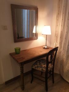 a table with a lamp and a chair with a mirror at maison de campagne in Jars