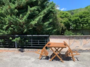 a wooden picnic table and two chairs next to a tree at RESIDENCE ROKIA - Au fil de l*eau in Royat