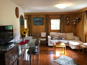 een woonkamer met een bank en een tafel bij Mes Lastei in Campitello di Fassa