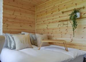 a bedroom with a white bed with a wooden wall at Fine Country Stays in Bubwith