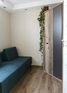 a room with a bed and a door with a plant at Apartament DINO in Ustka