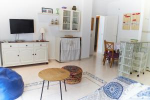 ein Wohnzimmer mit einem TV, einem Tisch und Stühlen in der Unterkunft Cala Gonzalez 17 in Alcossebre