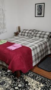um quarto com uma cama com duas toalhas cor-de-rosa em Recanto Chale dos Alpes - Chale com Lareira e Jardim em Monte Verde