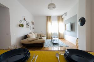 - un salon avec un canapé et une table dans l'établissement Stylized and modern apartment in Bucharest, à Bucarest
