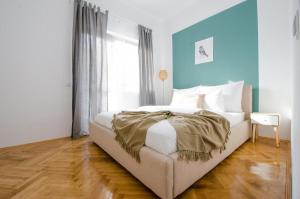 - une chambre avec un lit et un mur bleu dans l'établissement Stylized and modern apartment in Bucharest, à Bucarest