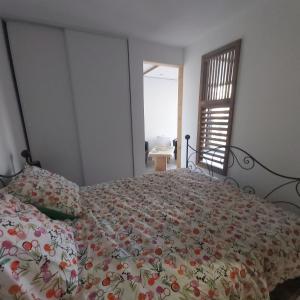 um quarto com uma cama com colcha floral em In casa em Casta