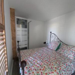 um quarto com uma cama com colcha floral em In casa em Casta