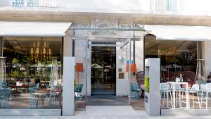 une façade de magasin avec des portes en verre, des tables et des chaises dans l'établissement Gran Hotel Nagari Boutique & Spa, à Vigo
