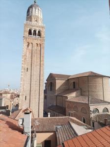 a tall clock tower in a city with roofs at Casa Micaela in Chioggia