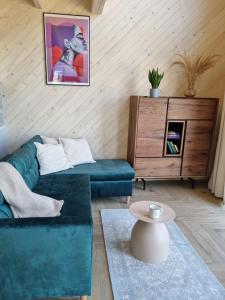 ein Wohnzimmer mit einem grünen Sofa und einem Tisch in der Unterkunft Wy_spa_Podolany in Gdów