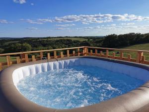 una bañera de hidromasaje en un patio con una valla de madera en noct enbulle, en Cabrerets