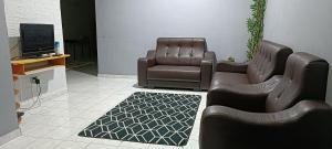 sala de estar con 2 sillas y TV en RUMAH INAP BANDAR PERDANA, en Sungai Petani