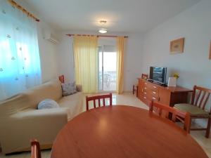 sala de estar con mesa y sofá en ACV - Marina Trebol III-2ª linea planta 1 norte-3h, en Oropesa del Mar