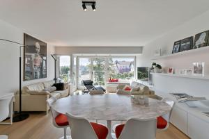 uma sala de estar branca com uma mesa e cadeiras em Top location! Unique luxurious 2-bedroom apartment in Knokke - 't Zoute em Knokke-Heist
