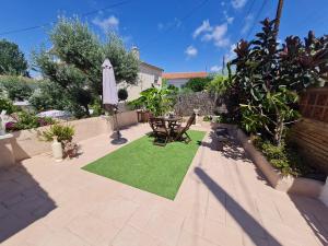 a patio with a table and a lawn with an umbrella at Casa con piscina privada Cesar - MarCalma in Creixell +1 photo