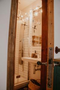 a bathroom with a sink and a shower at Zelta Apelsīna apartamenti in Kuldīga