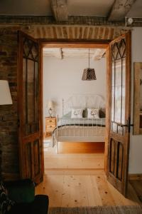 an open door into a bedroom with a bed at Zelta Apelsīna apartamenti in Kuldīga