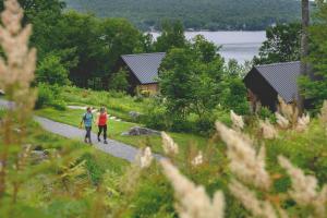 two people walking down a path in front of a cabin at Duchesnay - Sepaq in Sainte-Catherine +183 photos