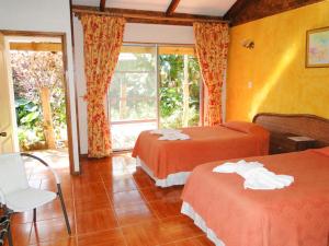 a hotel room with two beds and a window at Tupa Hotel in Hanga Roa