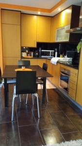 eine Küche mit einem Tisch und Stühlen in der Unterkunft Blue Sea Nazaré Apartament in Nazaré