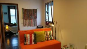 ein orangefarbenes Sofa mit gelbem Kissen im Wohnzimmer in der Unterkunft Blue Sea Nazaré Apartament in Nazaré
