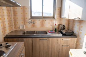 uma pequena cozinha com um lavatório e uma janela em Amazing Sea View, Rafina Port, Athens Airport, Self-Check-in em Rafina