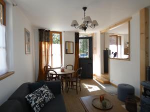ein Wohnzimmer mit einem Sofa und einem Tisch in der Unterkunft Chez Elise et Thomas in Le Mage