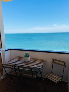 een tafel en 2 stoelen op een balkon met uitzicht op de oceaan bij Winston Mar y Sierra in Fuengirola