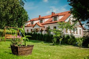 a large white house with a grass yard at Pod Kolumnami in Pilica