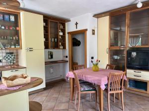 a kitchen and dining room with a table and chairs at Appartamento Fiore dell'Alpe in Premadio