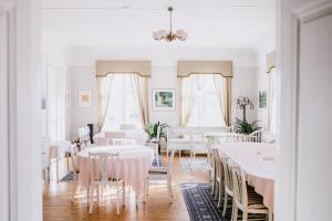 Tiittalan Kartano في Sulkava: غرفة طعام مع طاولات وكراسي بيضاء