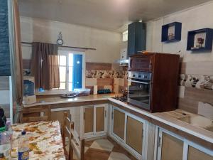 a kitchen with wooden cabinets and a counter top with a table at Suite home beldj in Tipaza