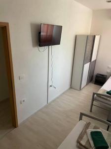 ein Wohnzimmer mit einem TV an der Wand in der Unterkunft Mediteran in Koper