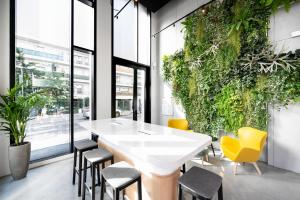 una sala da pranzo con tavolo bianco e sedie gialle di Staycity Aparthotels Paris La Defense a Courbevoie
