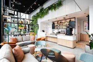 un salon avec des canapés, des tables et des plantes dans l'établissement Staycity Aparthotels Paris La Defense, à Courbevoie