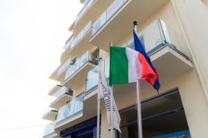 dos banderas volando fuera de un edificio en Hotel Felicioni, en Pineto