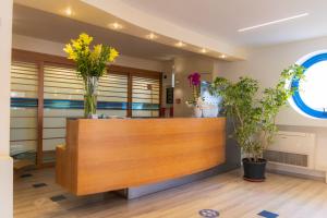 a reception desk with vases of flowers on top of it at Hotel Felicioni in Pineto