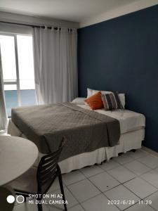 ein Schlafzimmer mit einem Bett und einer blauen Wand in der Unterkunft Flat Ponta Negra Beach - Ap 401 in Natal