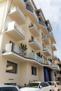 un edificio con balcones y coches estacionados frente a él en Hotel Felicioni, en Pineto