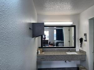 a bathroom with a sink and a mirror at Key West Inn - Tuscumbia in Tuscumbia