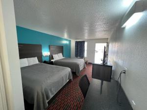 A bed or beds in a room at Key West Inn - Tuscumbia