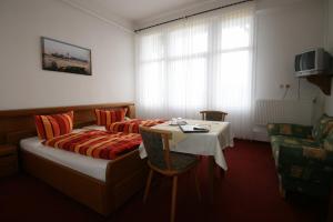 a hotel room with a bed and a table at Hotel Rummeni in Borkum