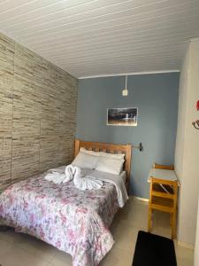 1 dormitorio con 1 cama con toallas en Pousada Maciel, en São Thomé das Letras