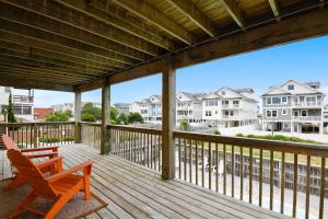 a deck with a chair and a view of condos at KD1105- Feels So Wright in Kill Devil Hills