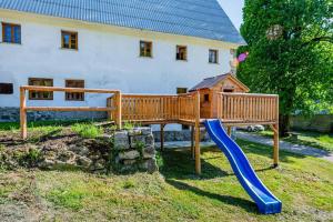 un parque infantil de madera frente a una casa en Domačija Gačnik, en Idrija