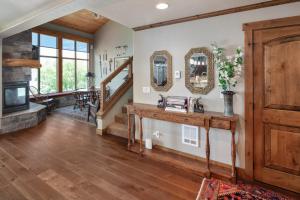 a living room with wood floors and mirrors at Lodge at Whitefish Lake in Whitefish