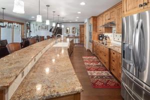 a large kitchen with a long counter and a refrigerator at Lodge at Whitefish Lake in Whitefish