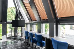 a bar with blue chairs in a room with windows at NEON APARTMENTS in Sopot