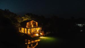 a lit up house on the water at night at Congo Bungalow in Ulcinj