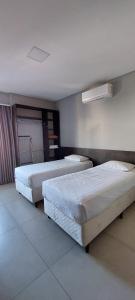 2 camas en una habitación de hotel con 2 camas en Vila Dumont no Centro de Foz, en Foz do Iguaçu